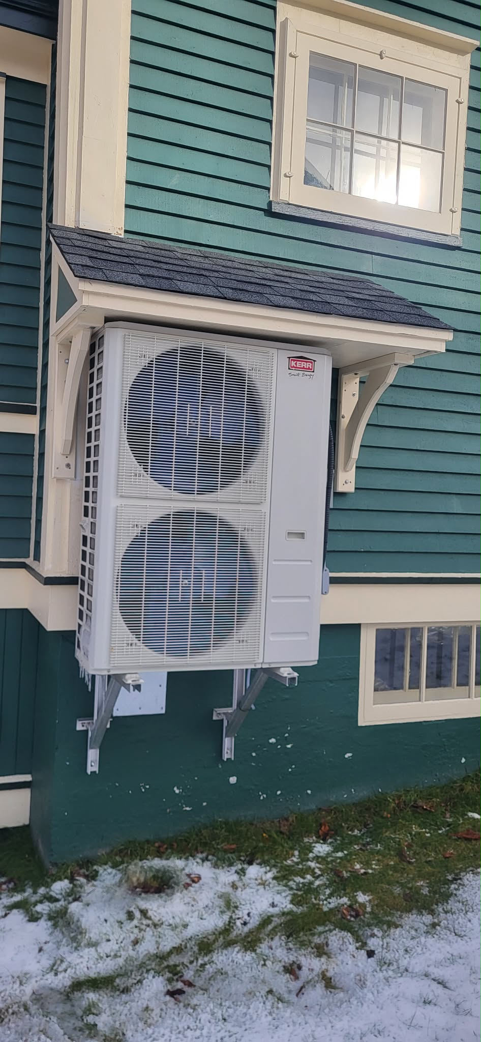 Kerr heat pump wall-mounted on teal house — winter install