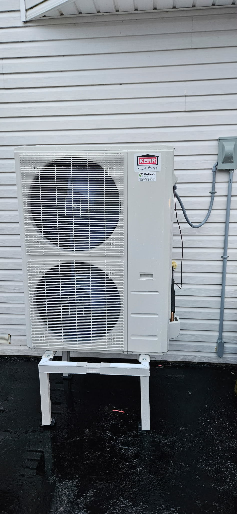 Kerr dual-fan outdoor heat pump unit on white siding